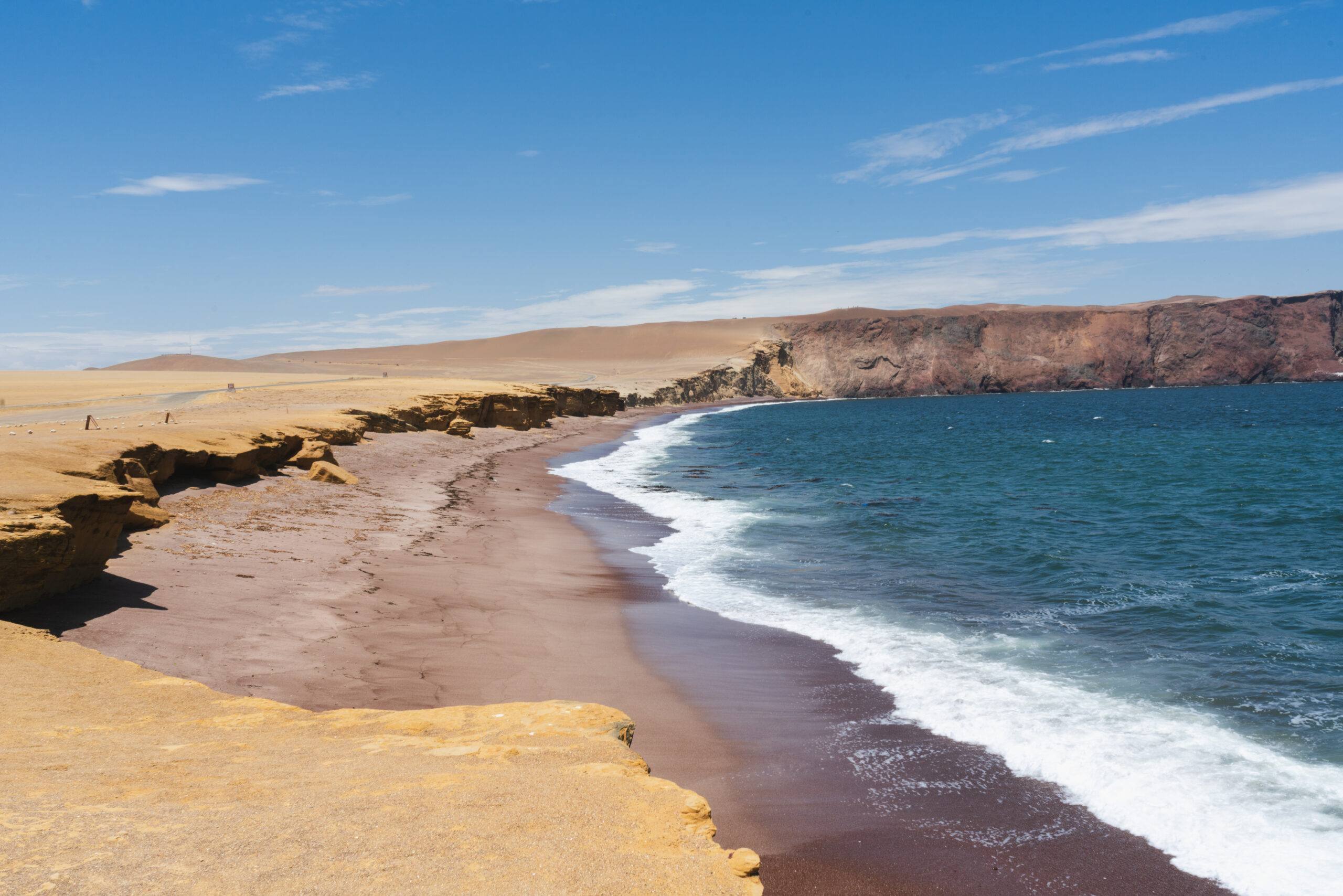 Playa Roja Paracas - Vista panorámica de la impresionante Playa Roja con sus aguas azules y la arena roja, ubicada en la región de Paracas Ica.