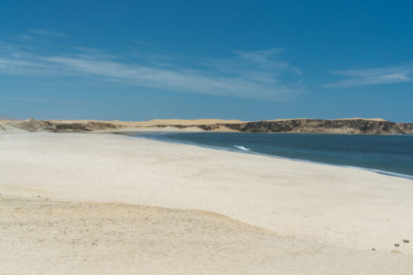 Playa Yumaque Paracas - Vista panorámica de Playa Yumaque, una playa tranquila con dunas doradas y aguas cristalinas, ubicada en la región de Paracas Ica.